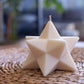 Star-shaped candle on a woven mat with a blurred indoor background