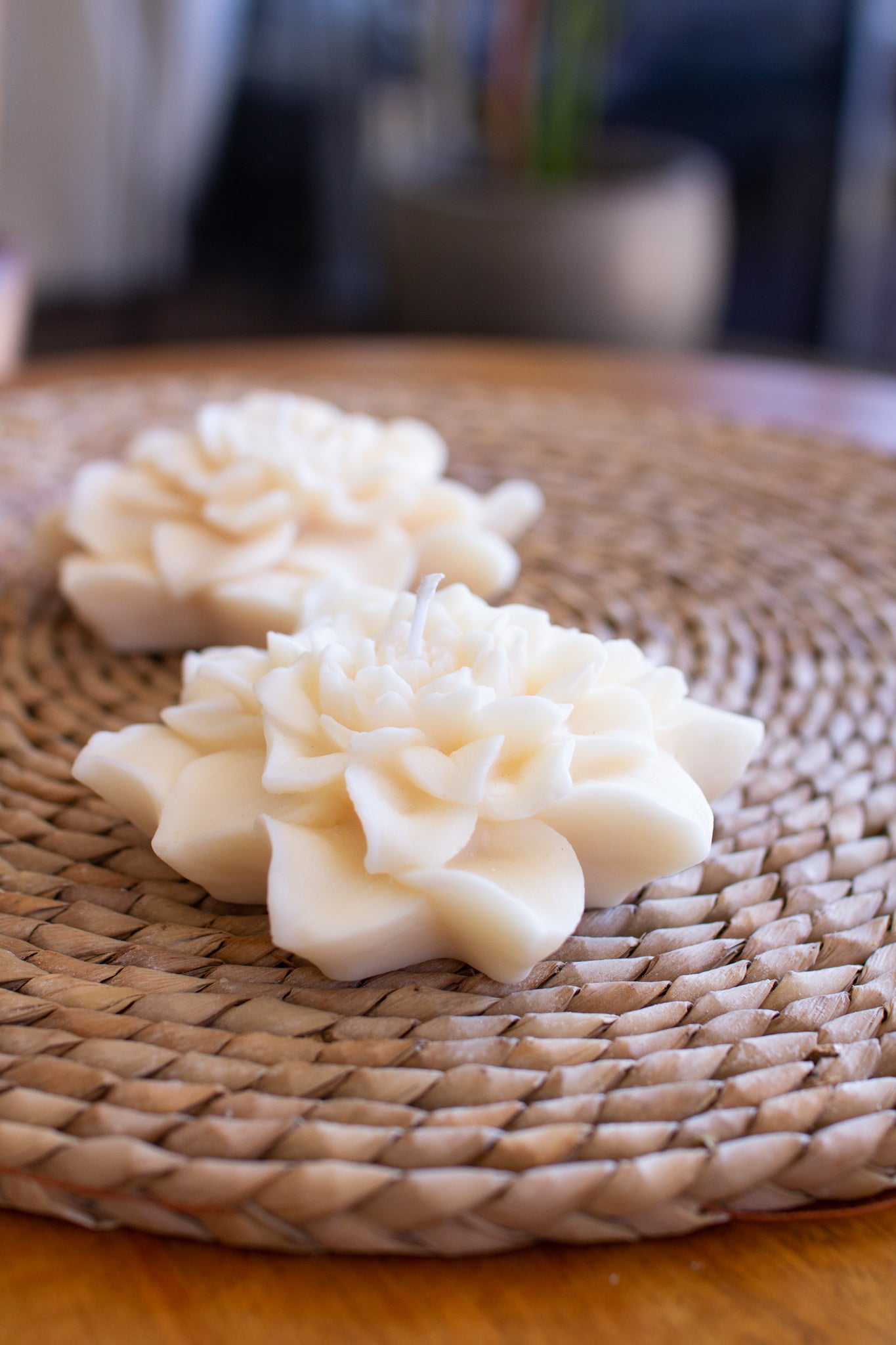 Decorative white flowers on a woven mat with a blurred background