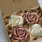 A gift box opened to reveal four rose-shaped candles inside. Two are white and two are a blush pink colour, all wrapped in a eco kraft box